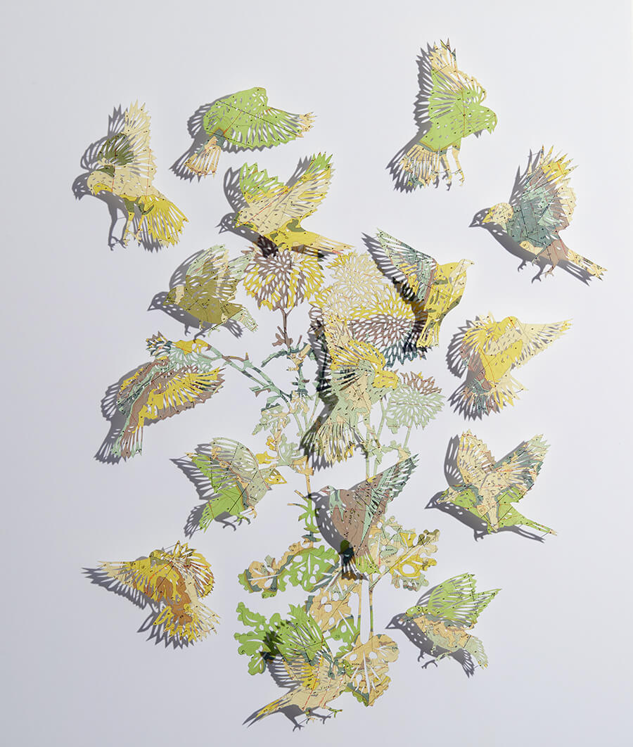 Seeing Through It by Claire Brewster. A paper sculpture of birds and foliage hand-cut from a vintage Geologic map of the San Lucas Dam Quadrangle, New Mexico, featuring yellow and green tones.