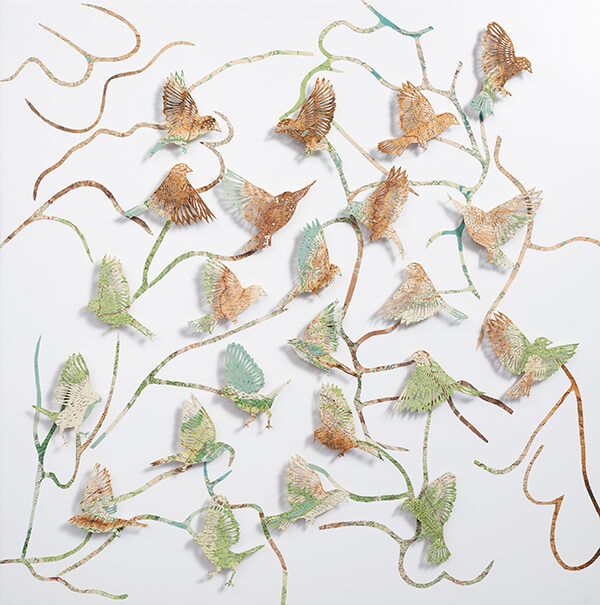Seeing The Future by Claire Brewster. A large paper sculpture of birds flying among winding, branch-like paths, hand-cut from pages of a vintage The Times Atlas in earthy green and brown tones.