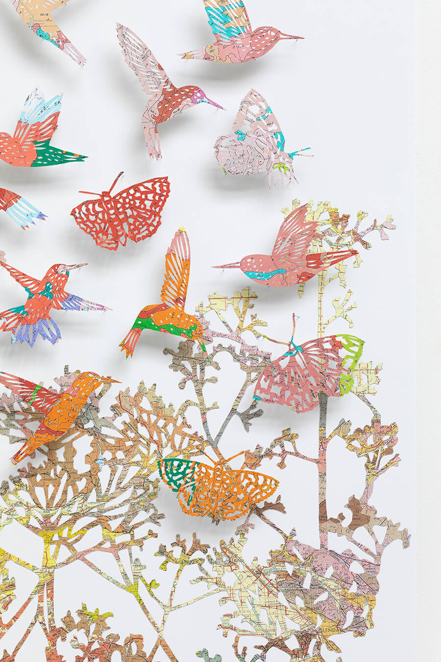 Close up detail of "We love life by Claire Brewster. A vibrant paper sculpture featuring hummingbirds and butterflies hand-cut from digitally printed vintage maps of California in bright blues, pinks, and oranges, commissioned for Stanford Children's Hospital."