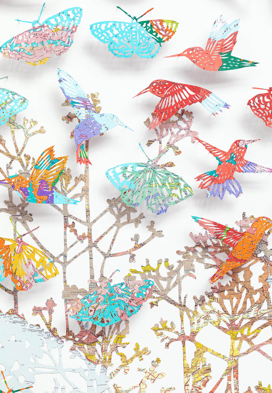 Close up detail of "We love life by Claire Brewster. A vibrant paper sculpture featuring hummingbirds and butterflies hand-cut from digitally printed vintage maps of California in bright blues, pinks, and oranges, commissioned for Stanford Children's Hospital."